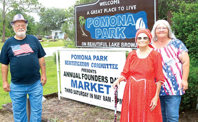TRISHA MURPHY/Palatka Daily News – From left, Mayor Joe Svingala, Pomona Park Beautification Committee Vice Chairwoman Yvonne Munn and committee Chairwoman Martha Mann stand near a sign notifying the public of the town’s 130th Founders Day event Saturday.