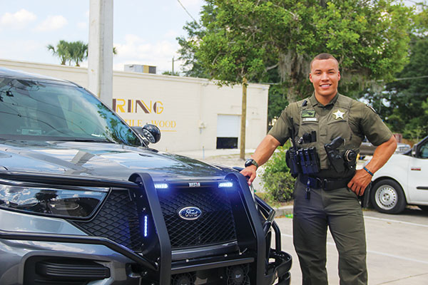 SARAH CAVACINI/Palatka Daily News – Putnam County Sheriff’s Office Deputy Alex Drummond stands next to his patrol vehicle Tuesday ahead of the “Police 24/7” premiere.