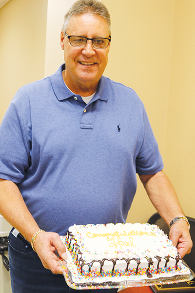 TRISHA MURPHY/Palatka Daily News – Hal Magee holds the cake guests were served at his retirement party.