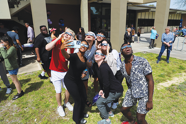 Photo submitted by Susan Kessler – A group of people take a selfie while staring at the solar eclipse Monday during St. Johns River State College's viewing party.