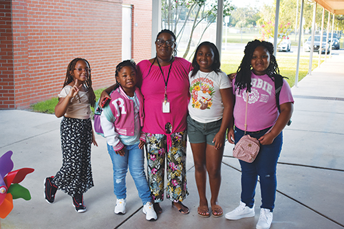 BRANDON D. OLIVER/Palatka Daily News -- Paraprofessional Reaco Johnson stands with some Moseley Elementary School students on the first day of class.
