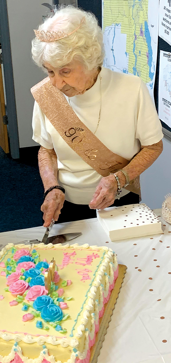 Submitted photo -- Pat Bennett cuts the cake at her 90th birthday celebration at the Putnam County Property Appraiser’s Office, where she still works two days a week as a mapper.