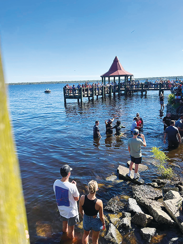 Photo courtesy of Facebook/Open Door Church of God – People gather Sunday in and around the St. Johns River in Palatka during the Community Baptism.