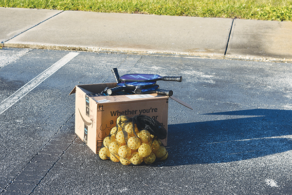 BRANDON D. OLIVER/Palatka Daily News – Pickleball paddles and balls sit in the parking lot of the former Jenkins Middle School in Palatka. The St. Johns River Pickleball Group donated 45 paddles, 100 balls and four portable net systems to the city of Palatka.