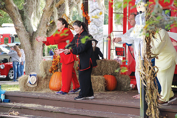SARAH CAVACINI/Palatka Daily News – Instructor Katy Goldapple, second from left, leads tai chi exercises Saturday at the caboose during the Interlachen Fall Festival.
