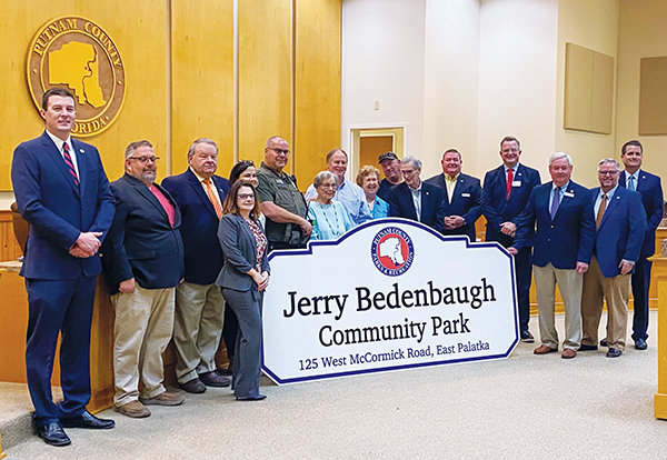 File photo – The Putnam County Board of Commissioners, county employees and Jerry Bedenbaugh's family stand in front of the official Jerry Bedenbaugh Community Park sign after its unveiling in May 2022.