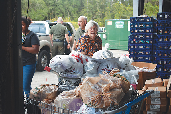BRANDON D. OLIVER/Palatka Daily News -- Epic-Cure volunteers sort food to be given out Wednesday.