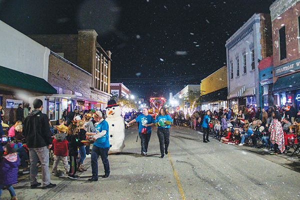 SARAH CAVACNI/Palatka Daily News – Palatka Daily News volunteers pass out candy Friday during the Palatka Christmas Parade, where they advertised the upcoming Snow Day that will occur Dec. 29.
