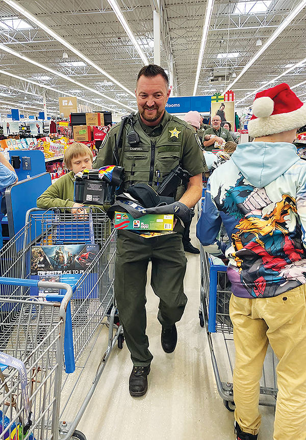Photos submitted by Allison Waters-Merritt - Putnam County Sheriff’s Office deputies and teens head to the checkout line after Christmas shopping Sunday during Shop with a Deputy.