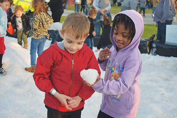 BRANDON D. OLIVER/Palatka Daily News – One of the children in the snow pit for younger frolickers offers her snowball to a fellow reveler.