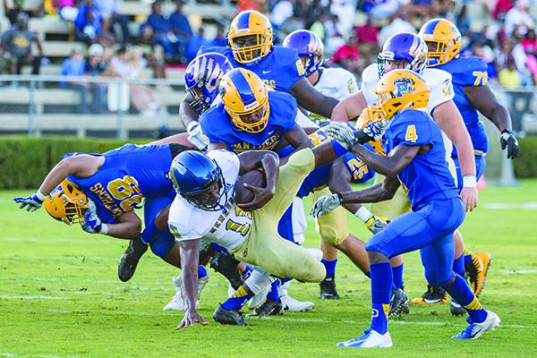 A host of Panthers upend Menendez quarterback King Benford in the first half of their game last Friday night. (FRAN RUCHALSKI / Palatka Daily News)