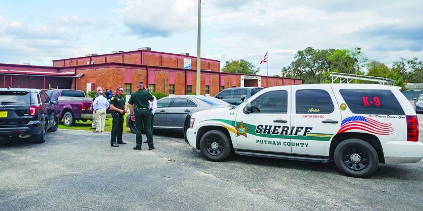 Law enforcement vehicles sit outside the Jenkins Middle School in February in response to a shooting threat for which several schools were put on lockdown.