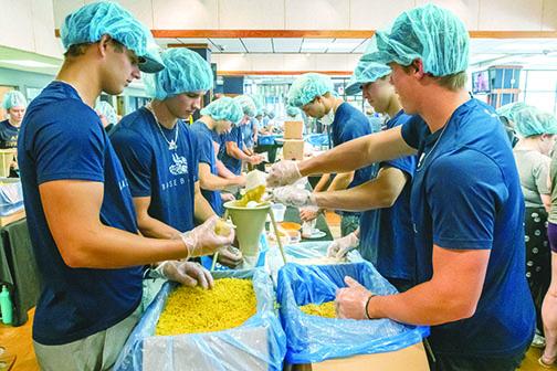 St. Johns River State baseball players pack macaroni and cheese for the Feed the Need program in the Viking Center on Tuesday afternoon.