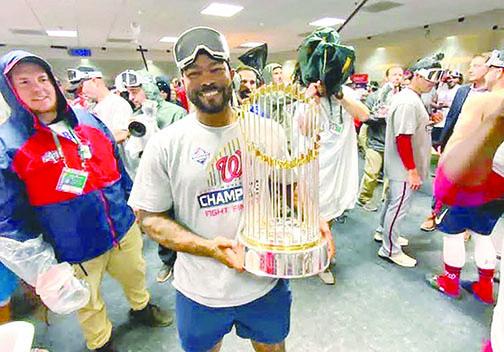Howie Kendrick holds the World Series trophy after Game 7.