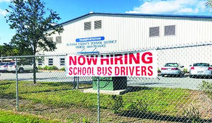 A banner advertises the need for school district bus drivers.