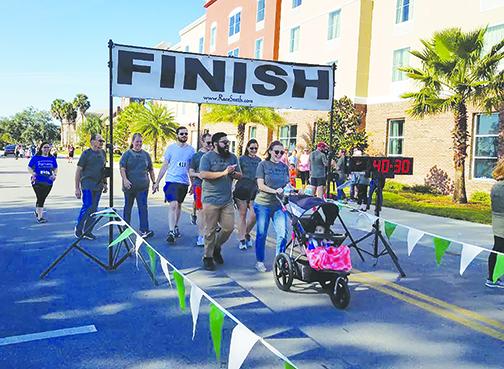Runners and walkers cross the finish line at the Trot for HOPE in Palatka. 