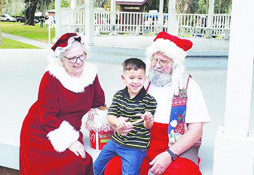 A little boy let's Santa and Mrs. Claus know what he wants for Christmas during Christmas in the Park in Crescent City.