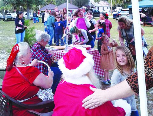 Children line up to see Santa and Mrs. Claus during the Florahome Christmas Market on Saturday.