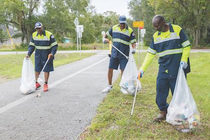 Palatka Public Works employees Eugene Cobbs, from left, Robert Smith and Isiah Seymour pick up debris along the bike trail by 19th Street in October.