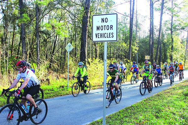 Bicyclists apporach Bardin Road on the Palatka-to-Lake Butler State Trail just aftet the start of Saturday’s Etoniah Gravel Ride. (ANDY HALL / Palatka Daily News)