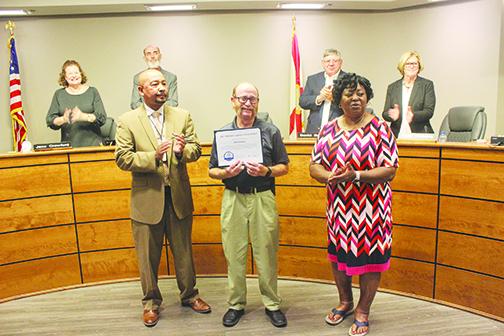 Bus driver John Brantley, center, stands with Assistant Principal Thomas Bolling and Transportation Director Sharon Spell at Tuesday’s school board meeting as he accepts his certificate for saving a student’s life.
