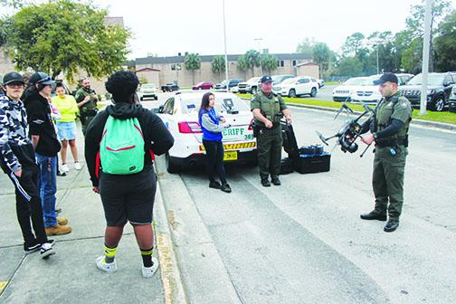 Deputies teach students how to fly drones.