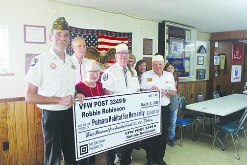 Members of Veterans of Foreign Wars Post 3349 in Palatka hold the $3,500 check the group is donating to Putnam Habitat for Humanity’s Veterans Village of Palatka on Monday.