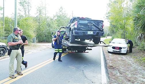 A tow truck operator loads a pickup truck the Putnam County Sheriff’s Office said was used in a drug-fueled high-speed chase Tuesday in Crescent City.