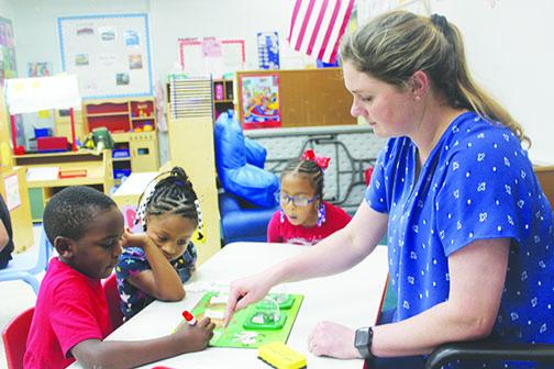 Assistant teacher Morgan Smith helps Moseley Elementary School prekindergarten students learn colors Thursday morning.
