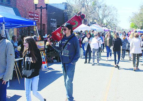 People attending the Azalea Festival on Saturday peruse the numerous vendor booths along St. Johns Avenue.