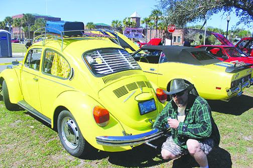 Don Rairigh puts a shine on the rear bumper of his 1972 Volkswagen Beetle Saturday during the car show at the 74th annual Florida Azalea Festival. Rairigh also brought along a 1972 Ford Mustang.