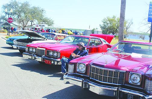 Pomona Park resident Dan Bowser enjoys lunch as he sits to the right of his 1974 Mercury Cougar during the car show Saturday.