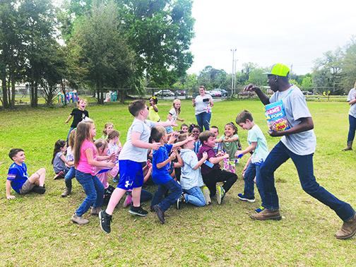 Jenkins Middle School’s Future Farmers of America President Cedric Wright gives candy to first-graders Tuesday during the second annual Farm Day.