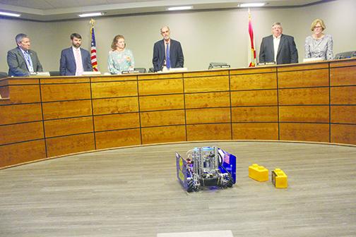 School board members look at a robot built by Palatka High School students.