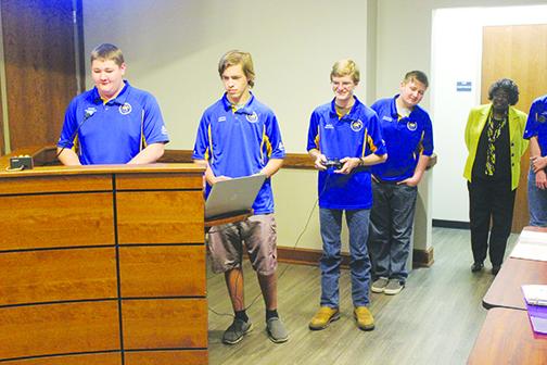 During the Putnam County School District board meeting Tuesday, Palatka High School robotics team members demonstrate how to use the robot they built and took to a competition in Jacksonville while board Chairwoman Sandra Gilyard watches.