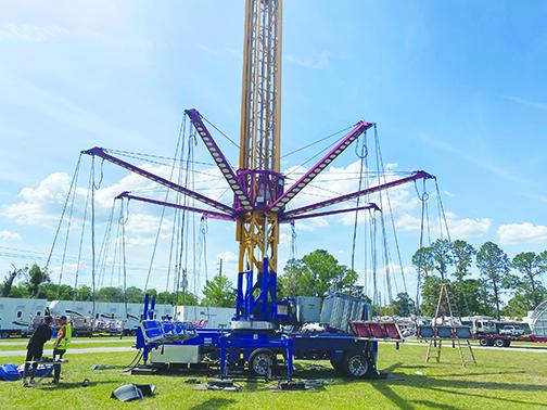 Workers construct a ride at the Putnam County Fairgrounds hours before organizers canceled the event because of coronavirus.