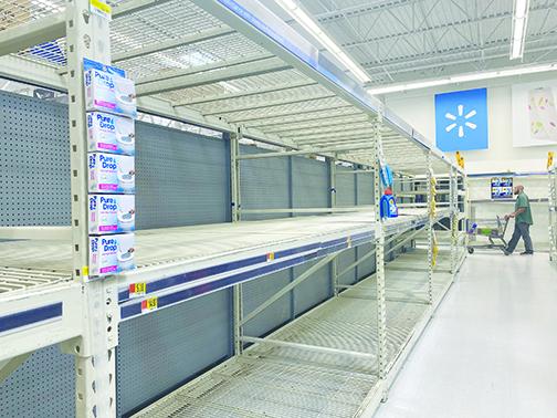 A shopper at Walmart looks for household items Friday, but the shelves in the cleaning aisles were bare amid fears of coronavirus.
