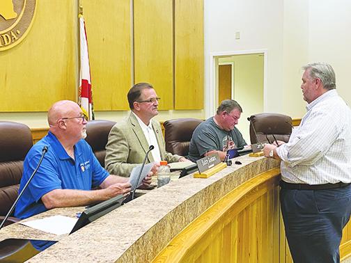 County Administrator Terry Suggs, right, talks with the three members of the Board of County Commissioners who could attend Friday’s emergency meeting.
