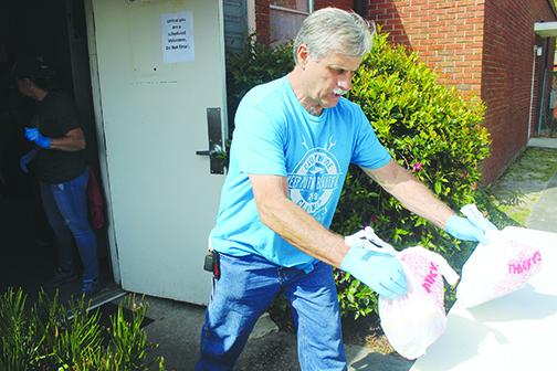 Bread of Life volunteer Donald Holton delivers food at First Presbyterian Church in Palatka on Tuesday.