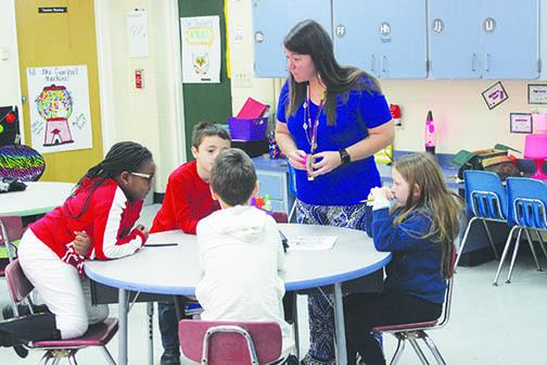 James A. Long Elementary teacher Kelli McGahey helps her first-grade students during a lesson in February.
