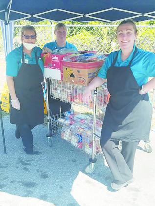 Hitchcock’s employees, from left, Shelia Schippers, Virginia McCullough and Kayla Mccostlin prepare to distribute food Saturday.