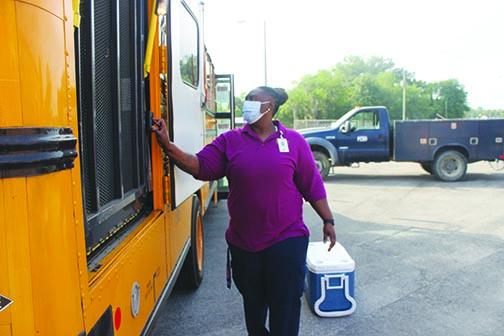 Keyonda Gilmore, Putnam County School District’s central location route coordinator, loads a bus with food Thursday to distribute to students through the district’s feeding program.