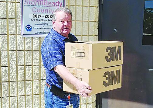 Putnam County Commission Chairman Terry Turner carries the N95 masks donated by Marty’s Trailer Depot in Palatka into the Emergency Operations Center.