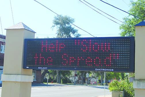 A sign leading into Crescent City’s business district reads “Help ‘Slow the Spread’” to remind residents coronavirus is still a threat to public health. 