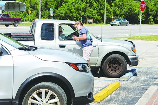 Diane Dibble takes customers’ orders from their vehicles Wednesday at Musselwhite’s in East Palatka.