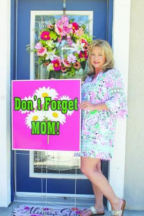 Melanie Wells, owner of Flowers by Melanie Inc. in Palatka, holds a display encouraging people to buy bouquets for the holiday. 
