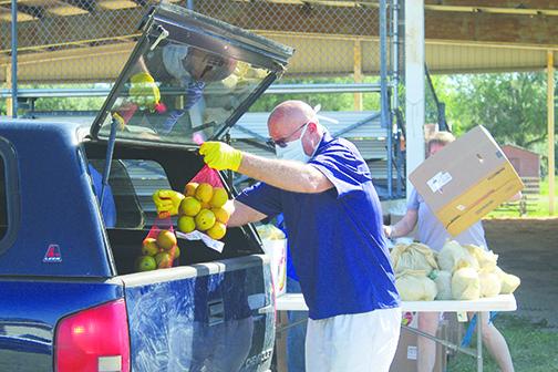 Local officials volunteer Wednesday at the drive-thru Farm Share distribution in East Palatka.