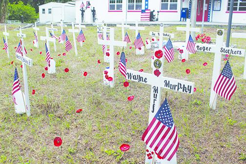 The post is decorated with crosses to memorialize servicemembers who never returned home.