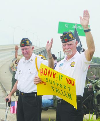 American Legion Bert Hodge Post 45 members wave to cars Monday in Palatka to honor members of the military.