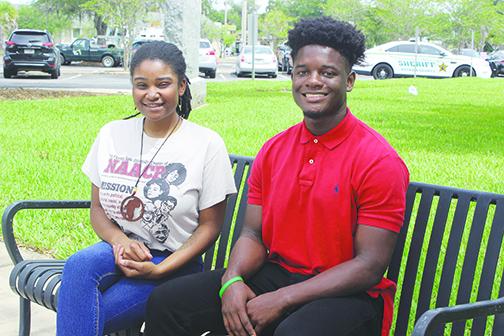 Putnam County natives Tevel Adams and Dar’Nesha Leonard sit outside the county courthouse Wednesday as they make preparations for today’s protest.